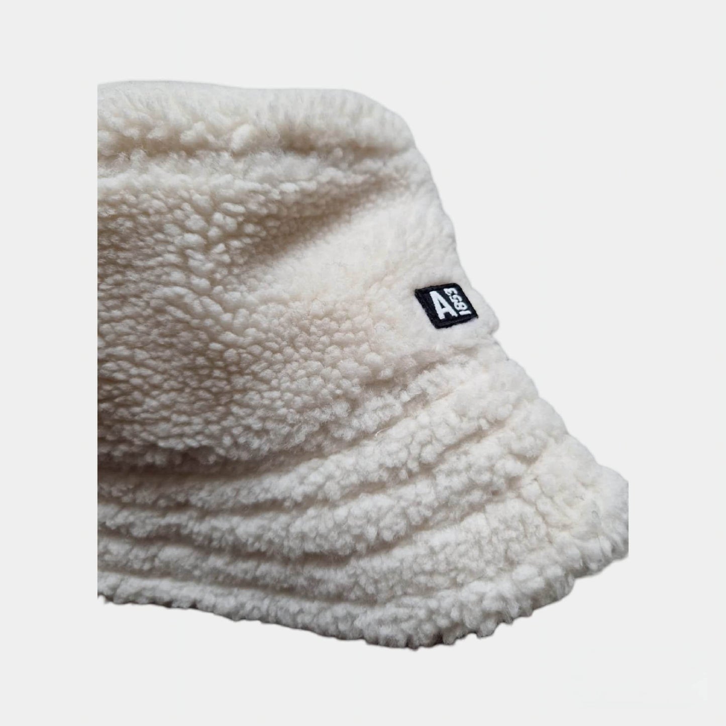 Gros plan sur la matière en fourrure douce du bob blanc AIGLE 1853