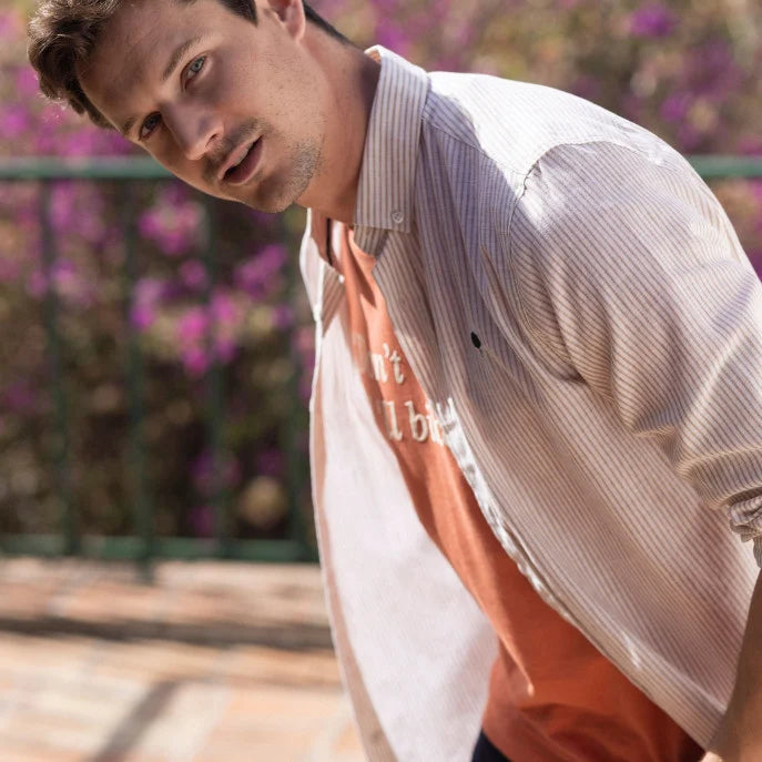 Chemise Ivory FAGUO rayée beige et camel portée avec un jean brut et des sneakers blanches pour un look imprimé élégant