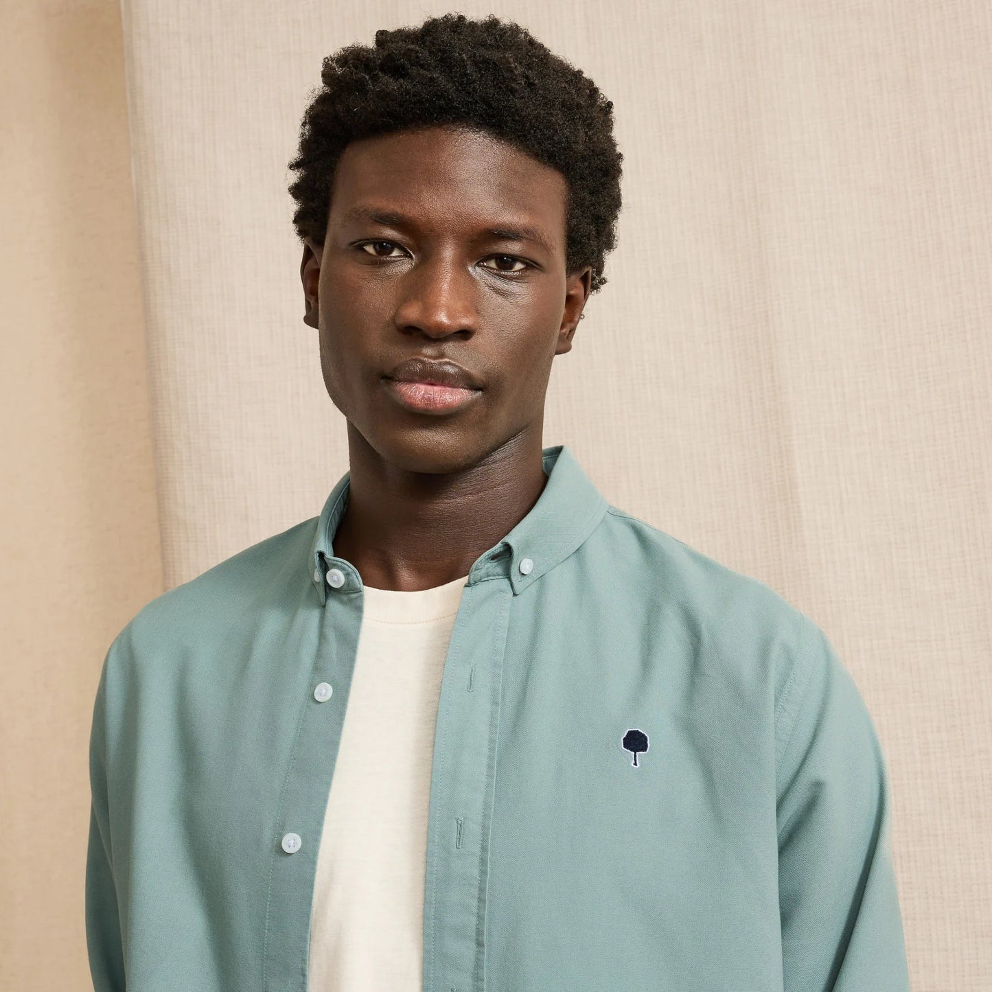 Chemise IVOY vert d'eau FAGUO portée avec un chino beige et des sneakers blanches pour un look casual chic