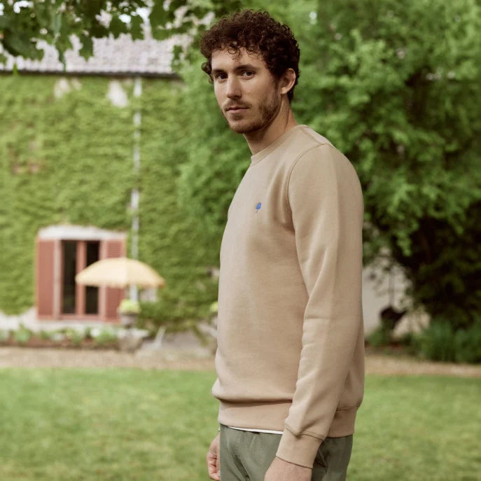 Sweat FAGUO beige porté avec un jean et des baskets blanches pour un look casual chic
