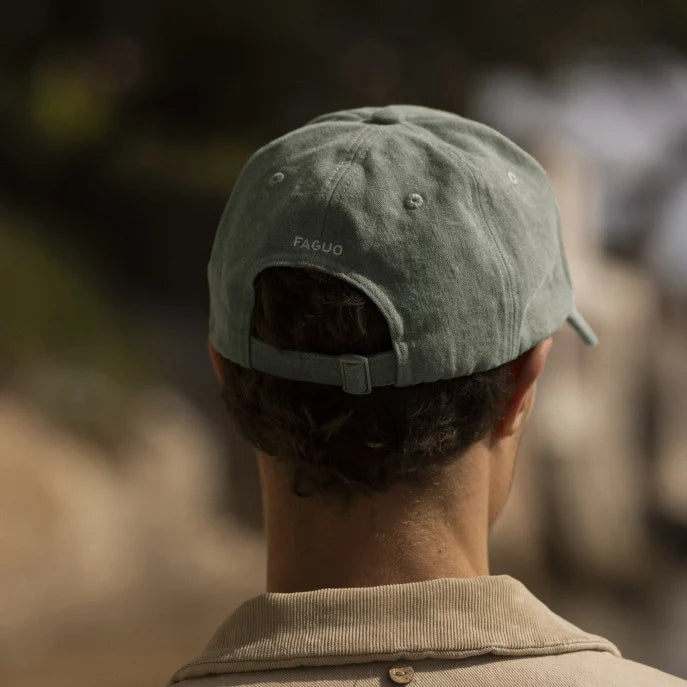 Casquette vert kaki FAGUO portée avec un t-shirt blanc et un short en denim

